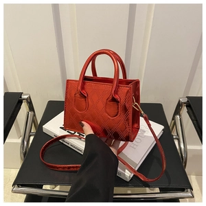 Macro view of red metallic rhombus quilted mini tote bag with dual handles and strap