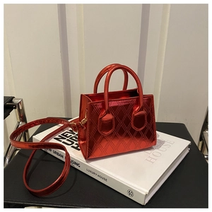 Macro detail of metallic red crossbody bag with quilted pattern and dual top handles