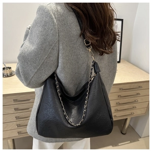 Détail du sac hobo noir à grain de litchi avec chaîne dorée et bandoulière réglable