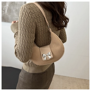 Detail of apricot crescent bag with pleated texture and silver bow buckle for women