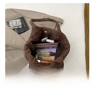 Vue de dessus de l'intérieur spacieux du sac cabas matelassé marron avec accessoires