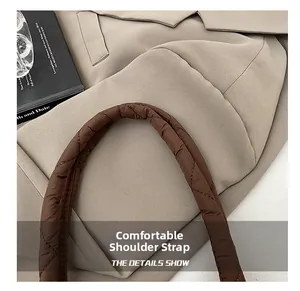 Détail de la bandoulière de sac fourre-tout matelassé marron avec surpiqûres en losange