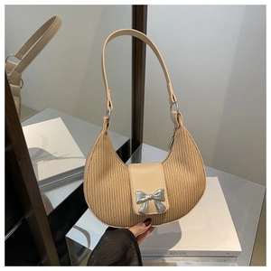 Detail of crescent shoulder bag featuring pleated fabric and silver bow metallic clasp
