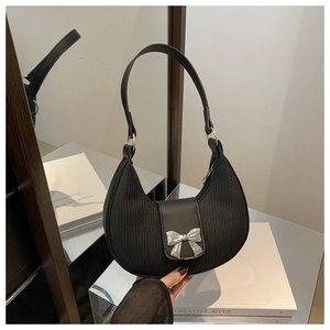 Detail of silver bow accent and textured fabric on black crescent shoulder bag