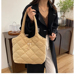 Détail du sac cabas matelassé beige avec pendentif cerf en métal et tissu en nylon