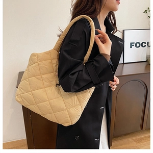 Détail du sac cabas matelassé beige avec losanges et large bandoulière rembourrée