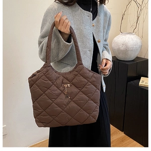Détail du sac fourre-tout matelassé marron avec motif en losange et breloque cerf dorée