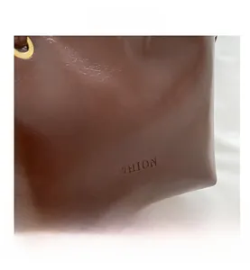 Macro shot of brown leather texture with embossed FASHION text and gold metal eyelets