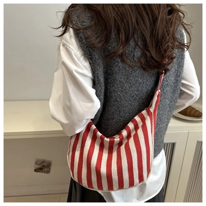 Vue de dos d'un modèle portant un sac hobo en toile à rayures rouges et blanches