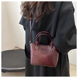 Détail du sac en cuir brillant bordeaux montrant sa structure et son gaufrage tendance