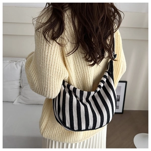 Striped black and white canvas crossbody bag styled with a minimalist knit sweater outfit