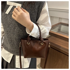 Gros plan d'un mini sac cabas en similicuir marron foncé avec texte gaufré