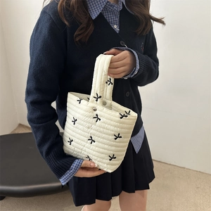 White quilted handbag with bow embroidery and single handle for women in minimalist style