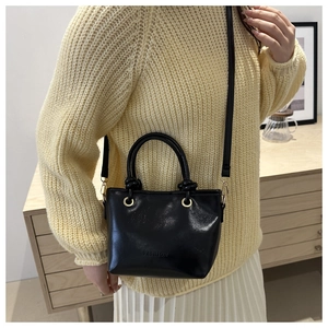 Détail du sac en similicuir noir avec gaufrage FASHION et accessoires dorés chic