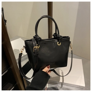 Détail du sac seau trapèze noir avec gaufrage FASHION et finitions dorées