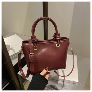 Gros plan d'un sac seau vintage bordeaux avec gaufrage FASHION et poignée ronde