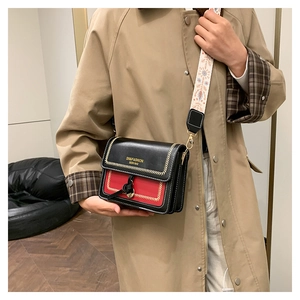 Detail of crossbody square bag featuring ethnic embroidered strap and contrast stitching