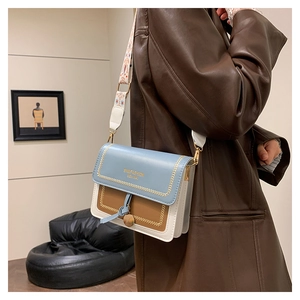 Detail of tricolor leather crossbody bag with jacquard strap and gold logo branding