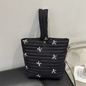 Borsa a mano trapuntata nera con fiocchi rosa ricamati e manico superiore