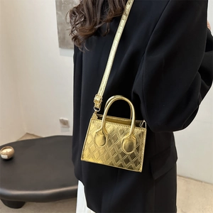 Golden quilted mini crossbody bag with metal texture and top handle for trendy styling