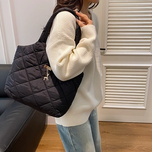 Grand sac cabas noir matelassé en nylon avec pendentif renne porté par un mannequin