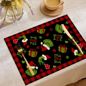 Dettaglio della tovaglietta natalizia Grinch con bordo a quadri rosso e nero e decori