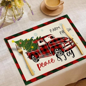Dettaglio delle tovagliette natalizie in lino con camion rosso e alberi festivi