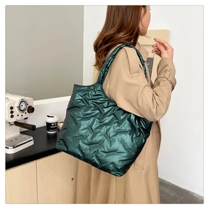 Side view of dark green quilted tote bag showing large capacity and shiny nylon texture