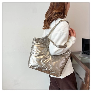 Close-up of a silver quilted tote bag with metallic finish shown in a daily lifestyle setting