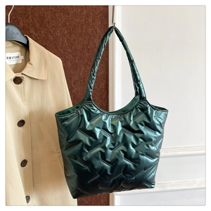 Detail of dark green quilted tote bag with glossy metallic finish and waterproof fabric