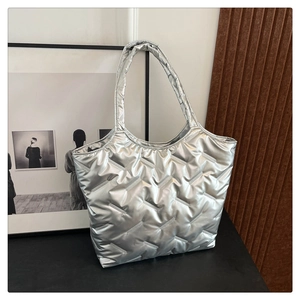 Close-up of a silver quilted tote bag with metallic sheen and soft padded texture details