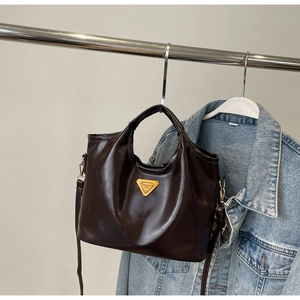 Vue détaillée du sac seau en cuir marron caramel avec logo triangulaire doré