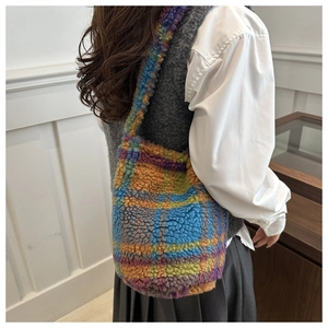 Détail du sac hobo en peluche à carreaux colorés montrant la texture et la bandoulière