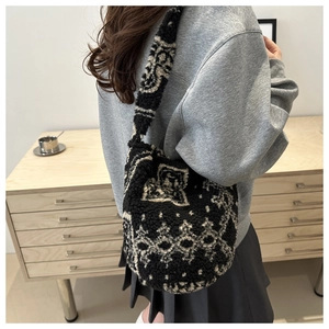 Sac à bandoulière en peluche avec motif floral vintage porté par un mannequin chic