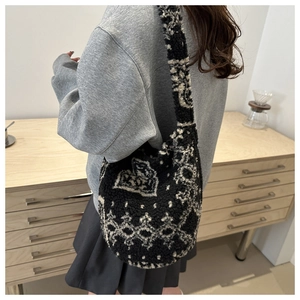 Détail d'un sac hobo en laine avec des motifs géométriques ethniques noir et blanc