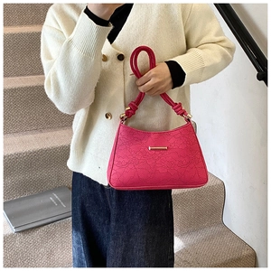 Close-up of pink lace texture bag with knotted handle and elegant gold metal accents