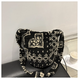 Détail du sac seau en peluche avec motif géométrique noir et blanc en laine sur cuir