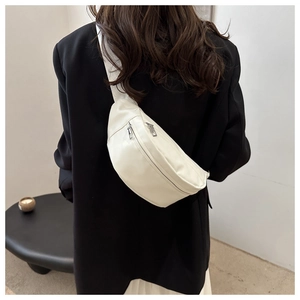 Détail d'un sac bandoulière blanc en demi-lune montrant deux fermetures éclair en métal argenté