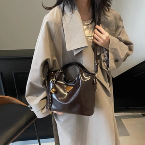 Sac seau chic en cuir verni marron foncé avec logo métallique et breloque cloche dorée
