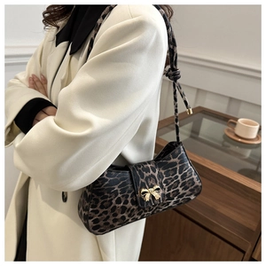 Detail der Leoparden-Schultertasche mit goldener Schleifenschnalle und Knotengurt