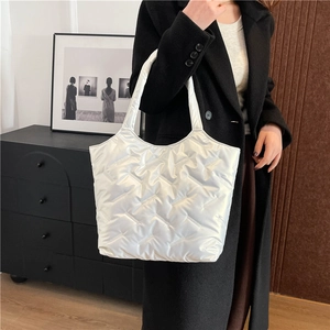 Modern white quilted puffer tote bag in glossy nylon for women's winter fashion styling