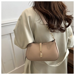 Detail van lichtbeige imitatielederen tas met elegante gouden sluiting en ketting