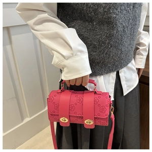 Detail of fuchsia cylinder bag with cherry blossom embossing and gold locks