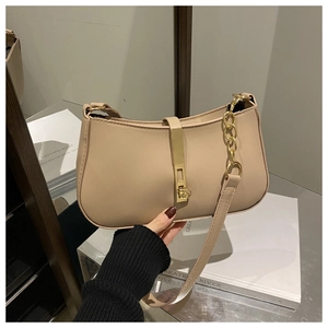 Detail van beige minimalistische okseltas met gouden metalen gesp en ketting schouderband