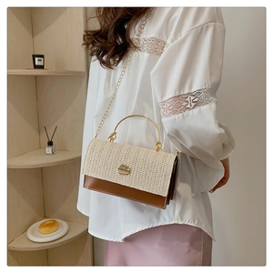 Détail du sac élégant en paille tressée et cuir marron avec poignée en métal doré