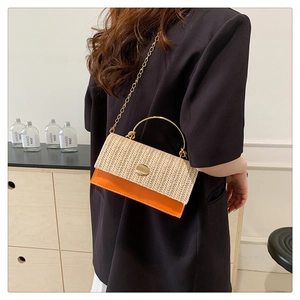 Détail du sac à bandoulière en paille tressée et cuir orange avec poignée dorée