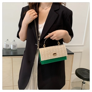 Détail du sac bandoulière en paille d'été avec contraste cuir vert et poignée en métal doré