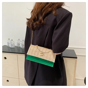 Close-up of woven straw and green leather crossbody bag with golden chain strap