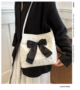 Détail du sac cabas blanc avec motif d'étoiles et grand nœud décoratif noir élégant