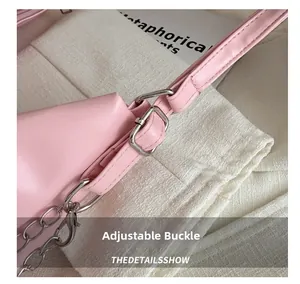 Close-up of pink pleated tote bag with adjustable silver buckle and metal chain detail
